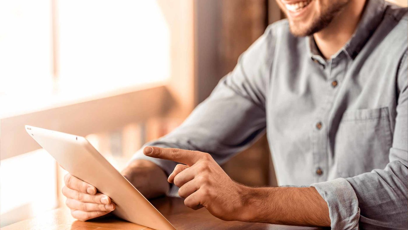 Lachender Mann mit Tablet